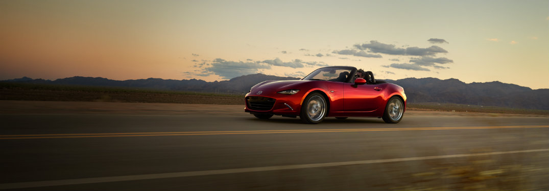 red mazda mx-5 miata on rural road