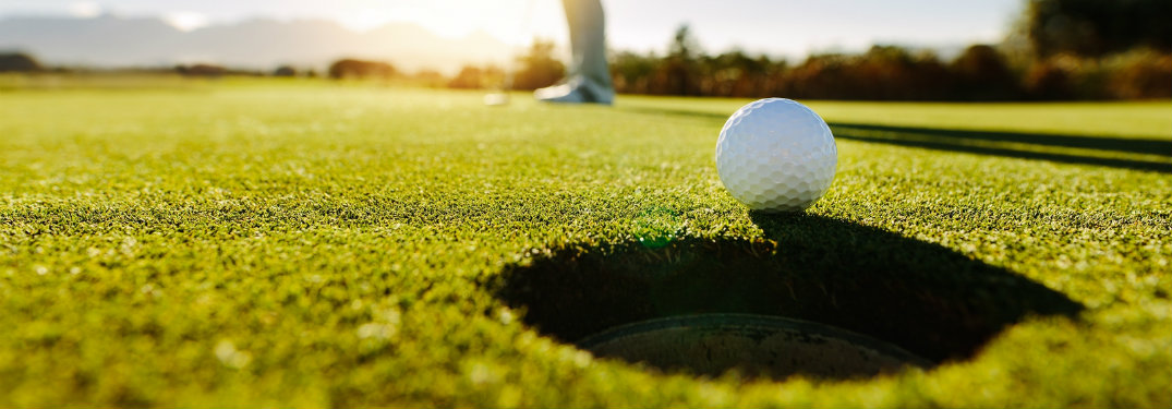 golf ball rolling into cup