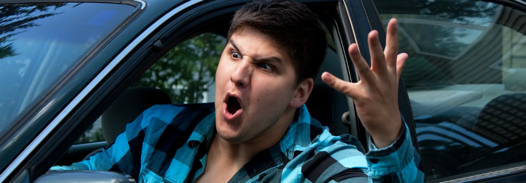 man in car expressing road rage