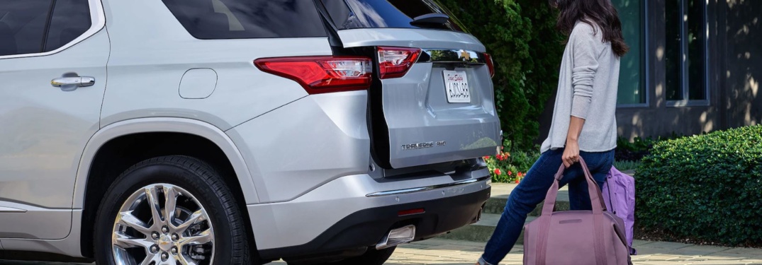 Woman loading gear into the back of a 2018 Chevy Traverse