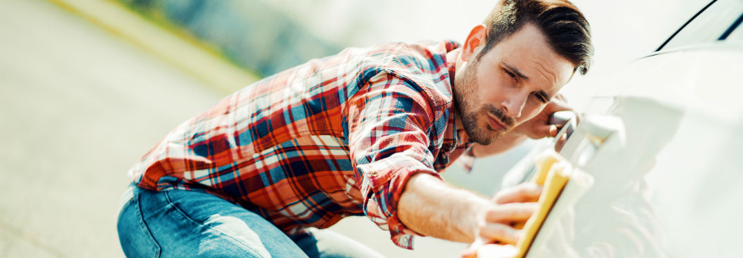 Man in plaid washing his car