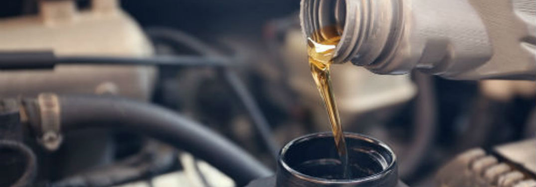Oil pouring from a bottle into an engine