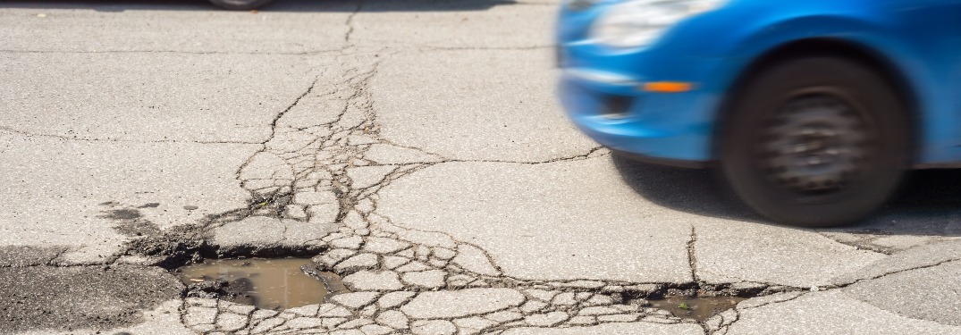 Car driving close to a pothole in the road
