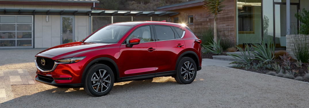 red 2018 mazda cx-5 in driveway of modern home