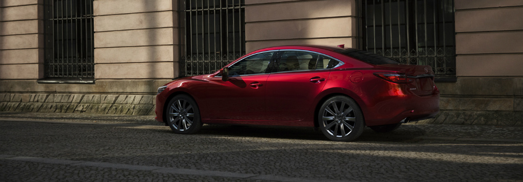 red 2018 mazda6 parked on city street in front of building