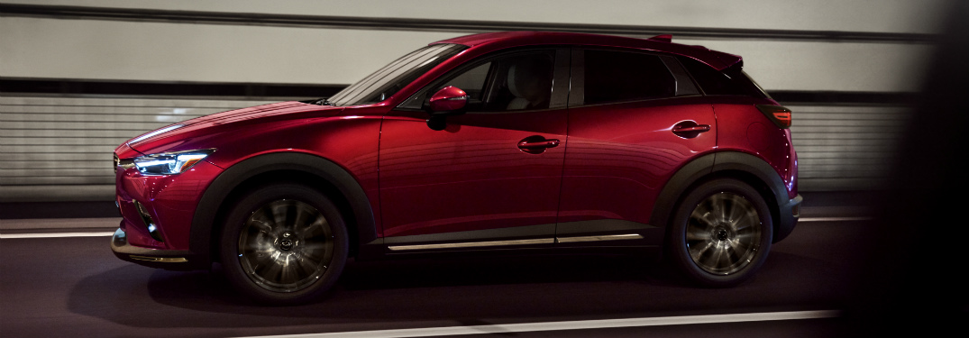side view of red 2019 mazda cx-3 driving through tunnel