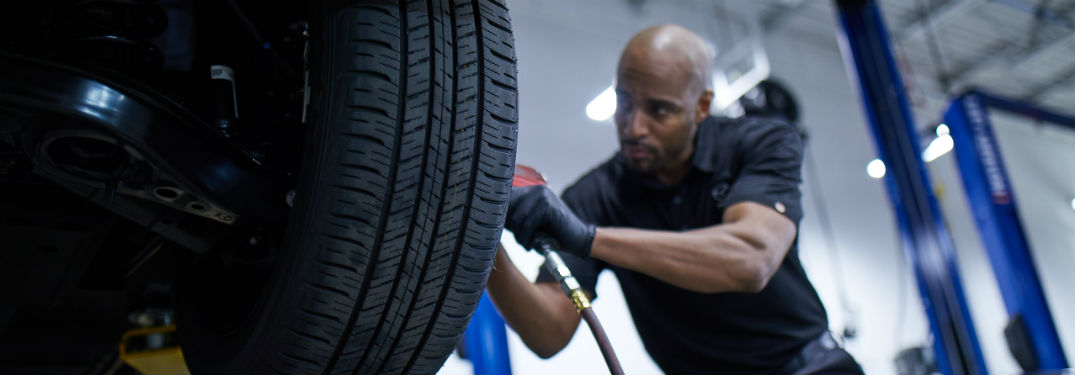 mazda auto technician working on tire