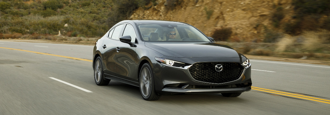 Grey 2019 Mazda3 driving by a hilly area