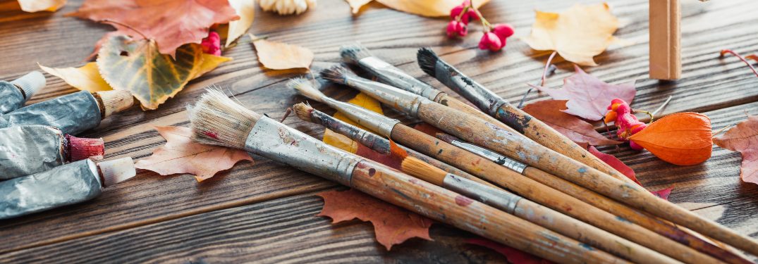 A set of brushes and leaves on a wooden table