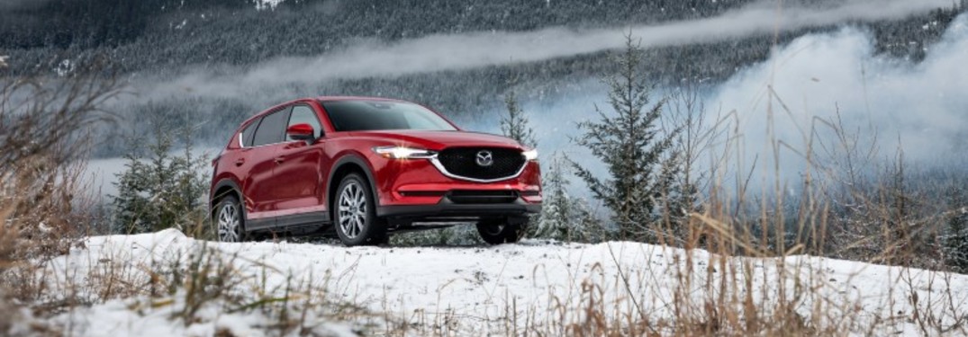 The front view of a red 2019 Mazda CX-5 parked on a wintry hill.