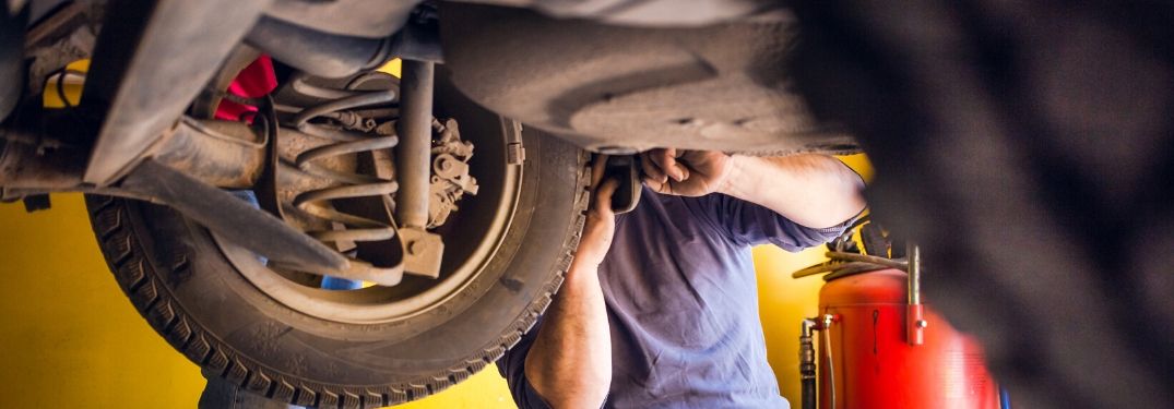 Man working on underside of vehicle