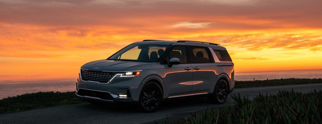 2023 Kia Carnival on the road against the sunset