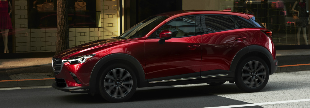 red 2019 mazda cx-3 driving down city street