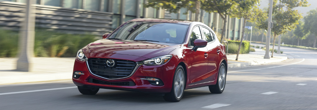 red 2018 mazda3 driving on empty street during the day