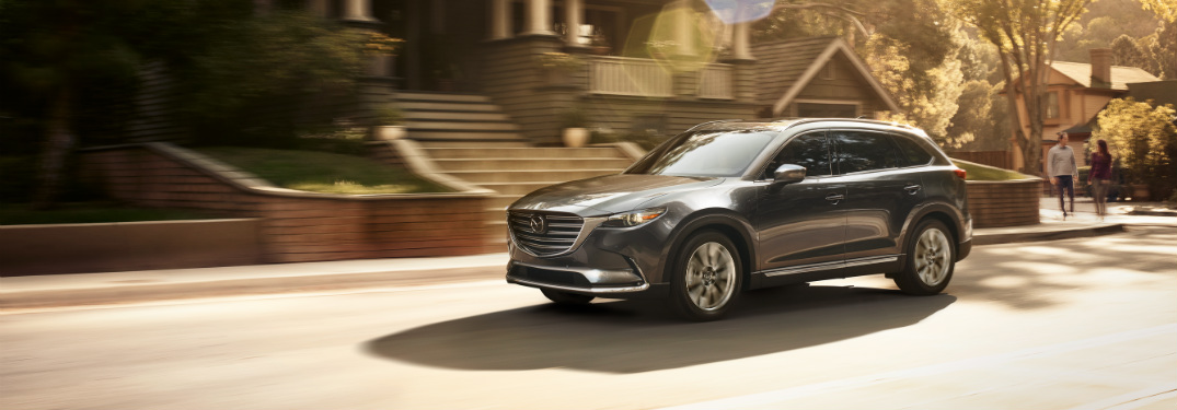 black 2018 mazda cx-9 driving through suburban road