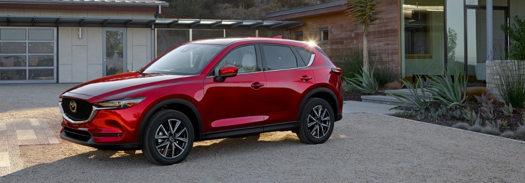 red mazda cx-5 in driveway of modern home