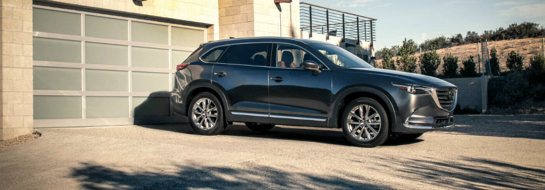 blue 2018 mazda cx-9 in driveway of modern home
