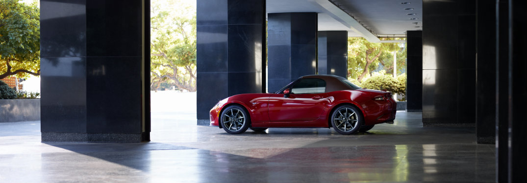 red mazda mx-5 miata parked in marble and concrete structure