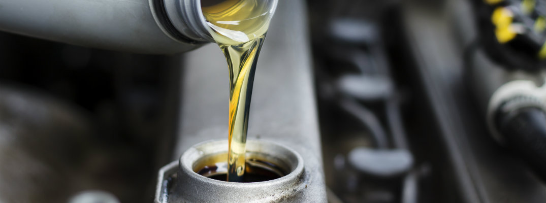 Oil being poured into engine in service bay