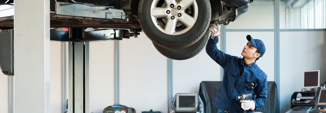 mechanic working on raised vehicle