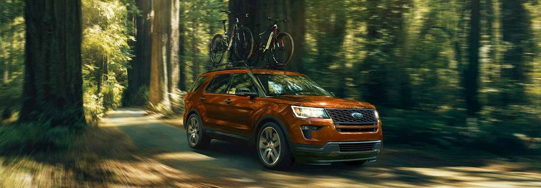 2018 Ford Explorer driving through forest with bikes on its roof