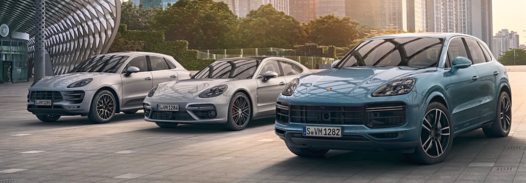Porsche lineup of vehicles in white with blue Cayenne the right