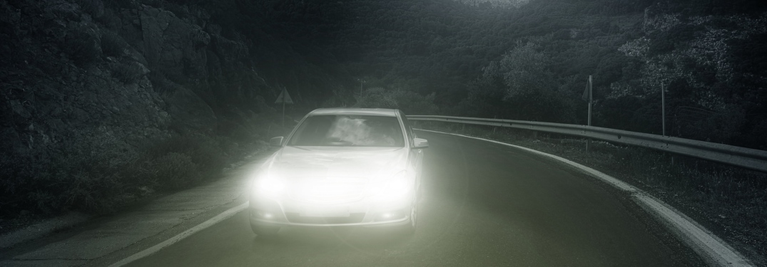 car driving at night on a road with bright headlights