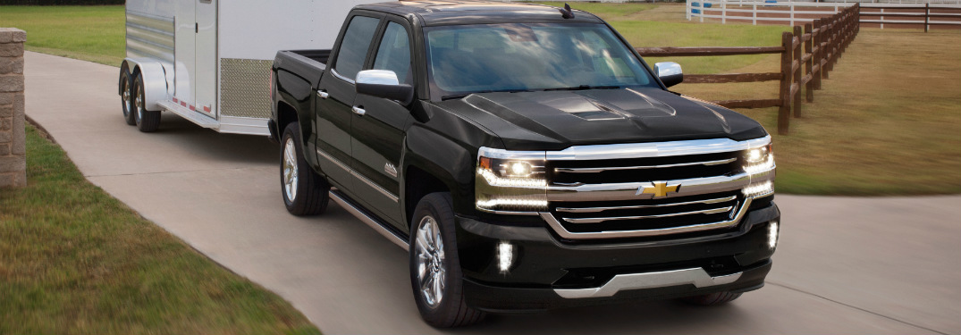 black 2018 chevy silverado 1500 towing trailer on driveway