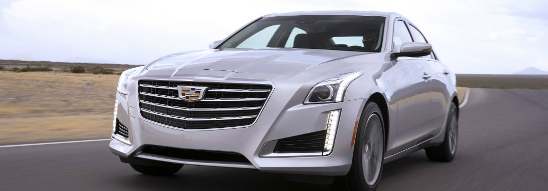 white 2018 cadillac cts sedan driving on open road