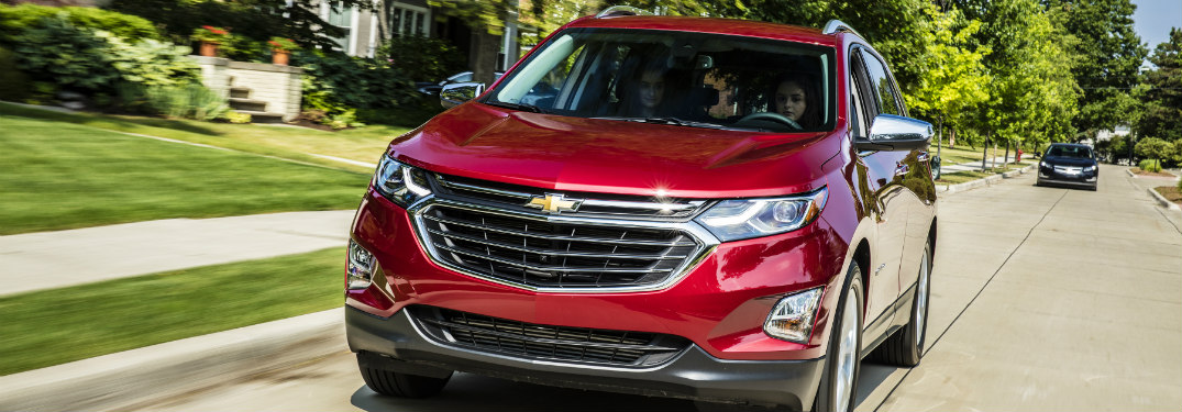 red 2018 chevy equinox driving on suburban road