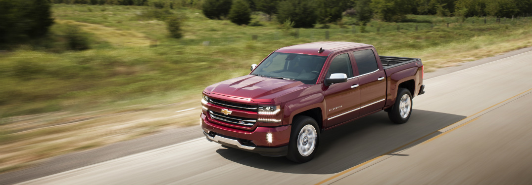 red 2018 chevrolet silverado 1500 driving on country highway