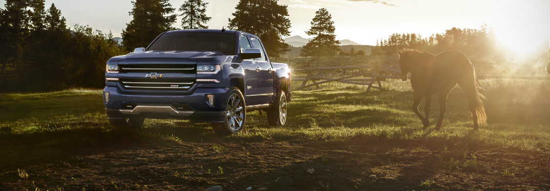 blue 2018 chevy silverado 1500 on farm with horse next to it at sunset