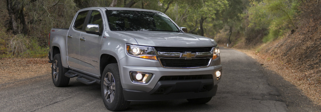 silver 2018 chevrolet colorado on paved trail in forest