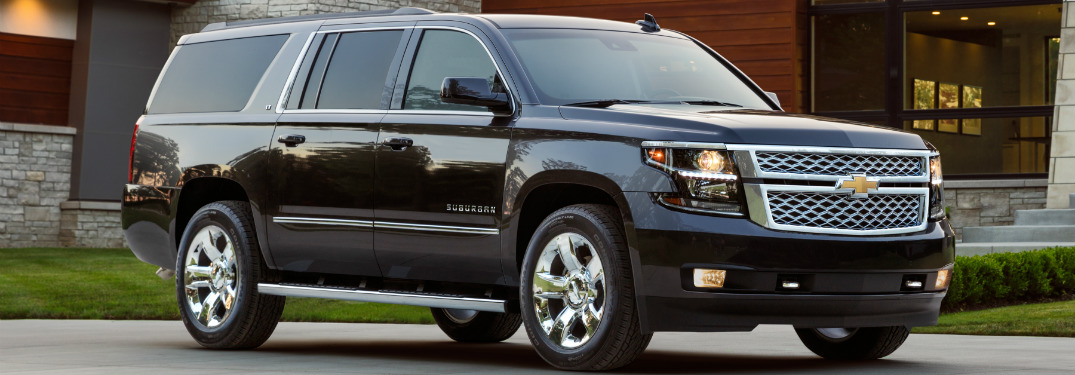 black 2018 chevrolet suburban in front of modern home
