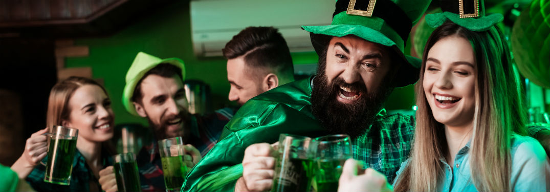group of friends wearing green and drinking beer
