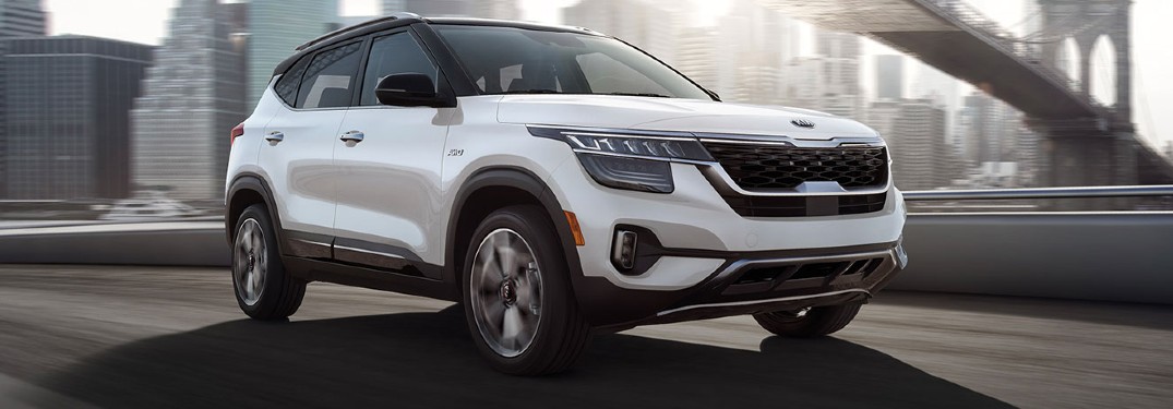2021 Kia Seltos white exterior front passenger side driving on bridge