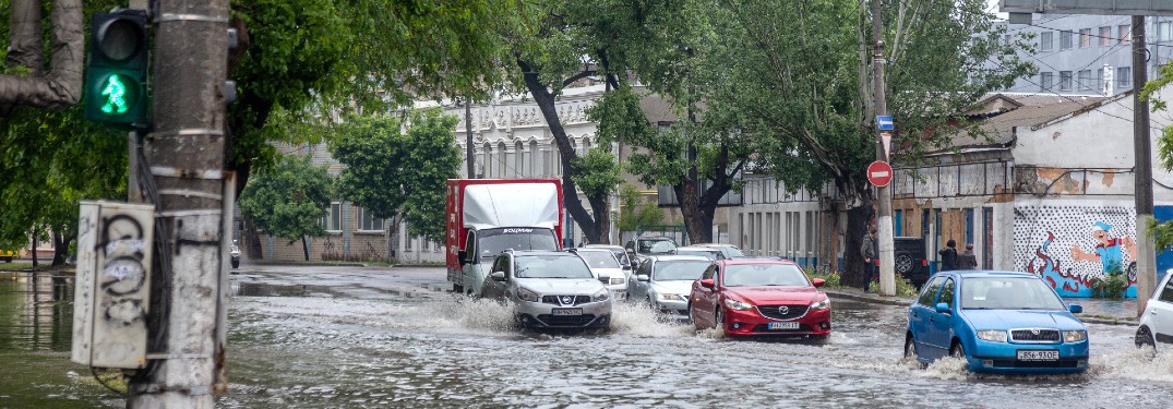 group of cars driving through a flooded city street