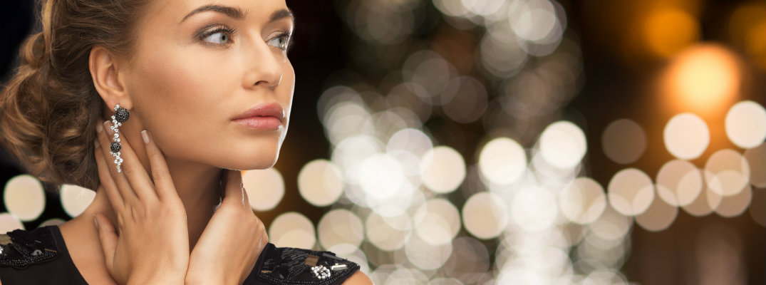 Woman wearing black dress and jewelry with bokeh background