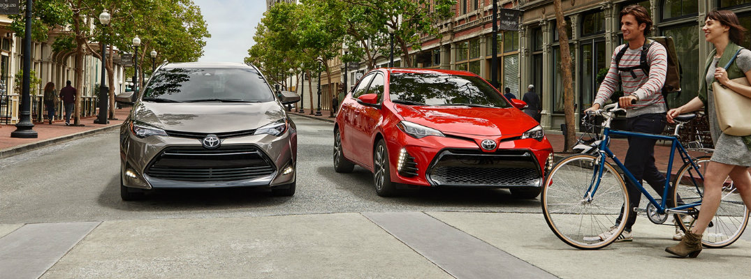 Gray and red 2018 Toyota Corolla models waiting for bikers to cross the street