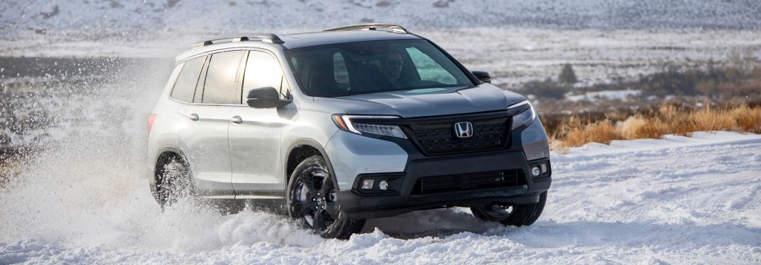 2020 Honda Passport driving through snow from exterior front passenger side