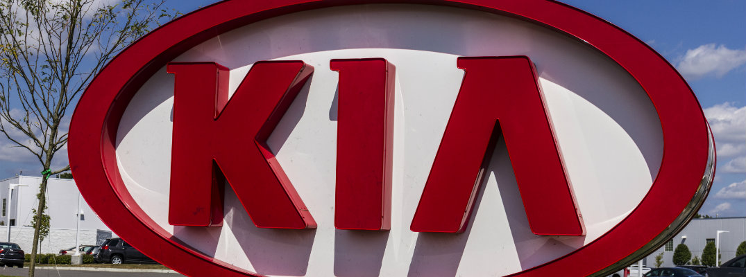 big KIA sign in the grass set outside a Kia vehicle dealership