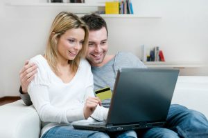 A man and woman looking at a laptop screen