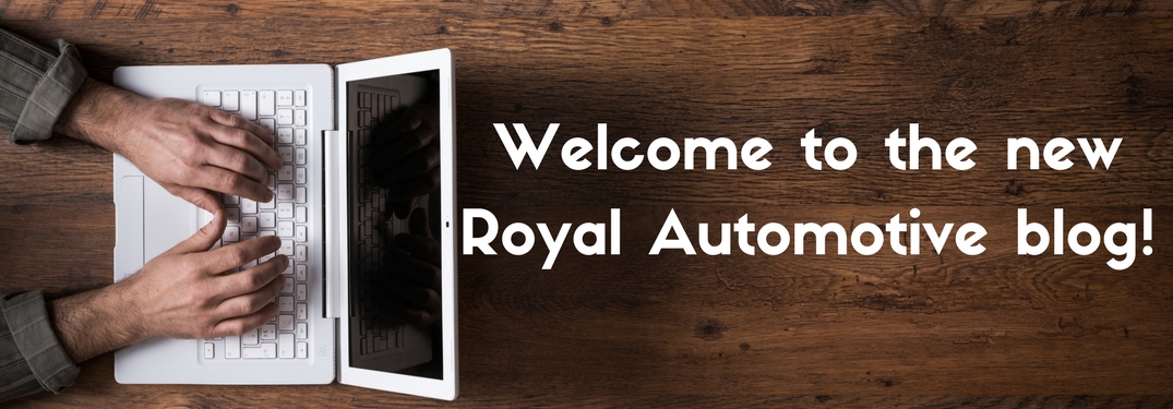 Man sitting at a wooden table typing on a white lap top next to text reading welcome to the new Royal Automotive Blog
