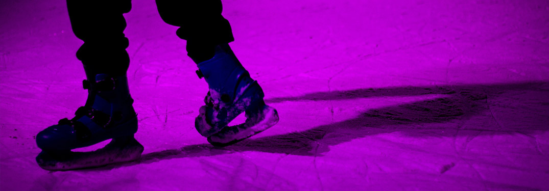 Close-up view of a person ice skating around a purple light
