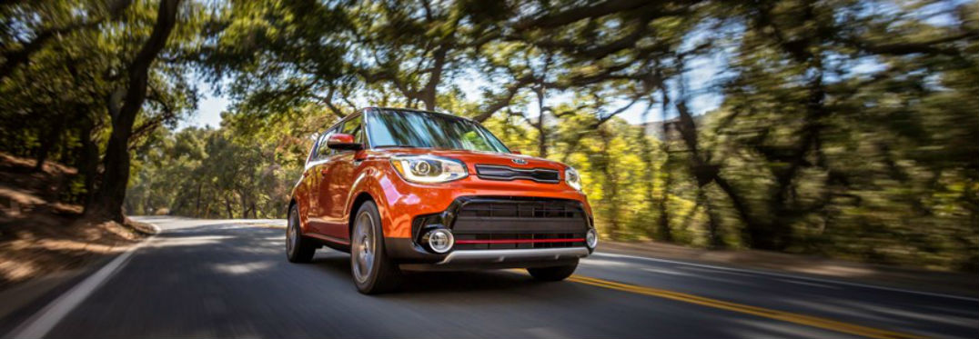 2018 Kia Soul Awarded Prestigious Accolades with image of a Kia Soul in orange driving past trees