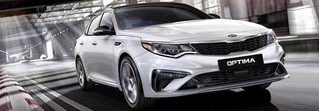 White 2020 Kia Optima on road from exterior front passenger view