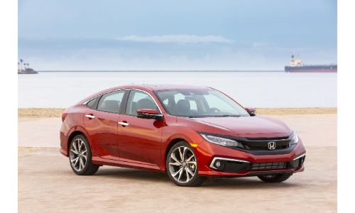 2020 Honda Civic Touring Sedan exterior shot with red painr color parked on a sandy beach