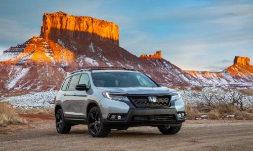 2020 Honda Passport exterior shot with gray silver paint color parked in a desert with an orange mountain background