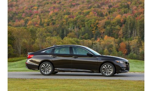 2020 Honda Accord Hybrid with crystal black pearl paint color exterior side shot parked outside of a forest