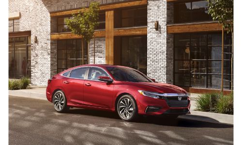 2021 Honda Insight exterior shot with Radiant Red Metallic paint color parked outside a fancy white and gray brick building